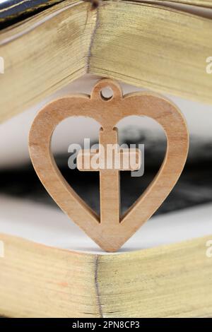 Bible with wooden heart with christian cross. Love and religion concept ...