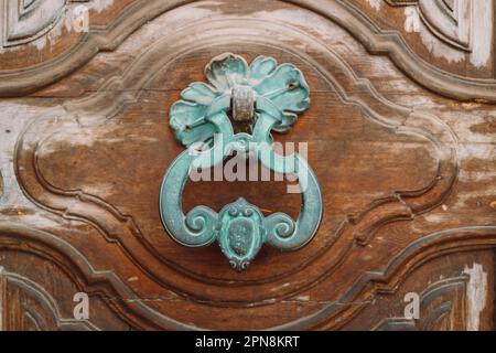 Iron door knocker on a wooden door. Pisa, Italy. High quality photo Stock Photo