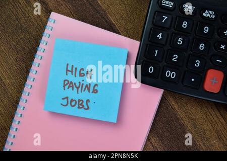 Concept of High Paying Jobs write on sticky notes isolated on Wooden Table. Stock Photo