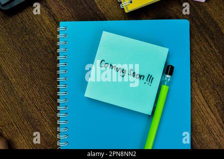 Concept of Coming Soon!!! write on sticky notes isolated on Wooden Table. Stock Photo