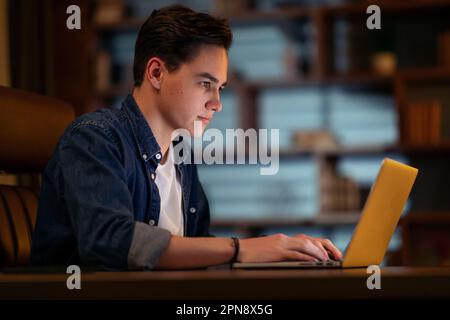 Concentrated young guy developer typing on pc keyboard, coding Stock Photo