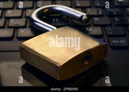 Detail of a metallic security padlock above a computer keyboard, Stock Photo