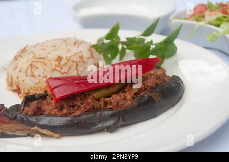 Karniyarık - Stuffed eggplant stuffed with minced meat and served with rice, salad and yoghurt Stock Photo
