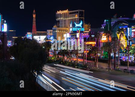 A picture of the Las Vegas Boulevard South at night, with many lit ads on the right.