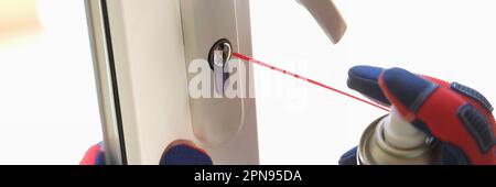 Repairman using lubricate for lock of plastic window Stock Photo