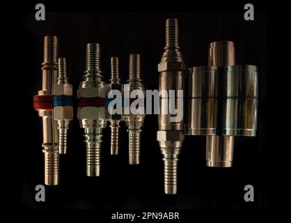 Set of fittings, quick couplings for hose isolated, bolts on a black background with reflection Stock Photo