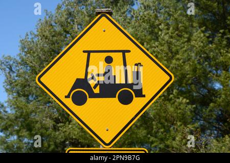 A golf cart crossing sign along a road warns motorists to watch for golfers and golf carts crossing the road in Abingdon, Virginia. Stock Photo