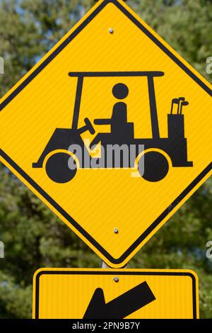 A golf cart crossing sign along a road warns motorists to watch for golfers and golf carts crossing the road in Abingdon, Virginia. Stock Photo