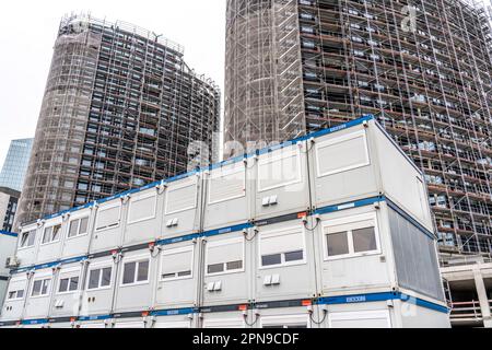 Large construction site, high-rise residential building, scaffolded shell, already fitted with windows, with Portakabin portable buildings in front Stock Photo