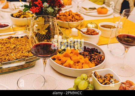 Close-up of the glass with red wine on the Thanksgiving dinner table decorated in warm colors Stock Photo