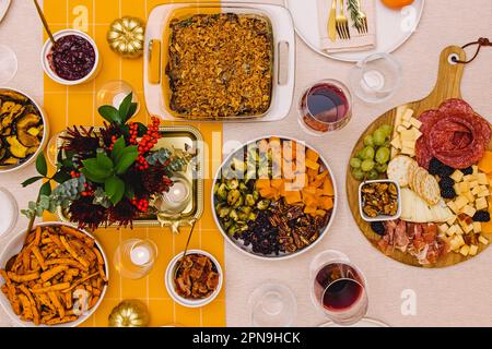 Thanksgiving dinner dishes on the table decorated with golden pumpkins, top view Stock Photo