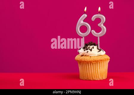 Birthday cake with candle number 63 - Rhodamine Red foamy background Stock Photo