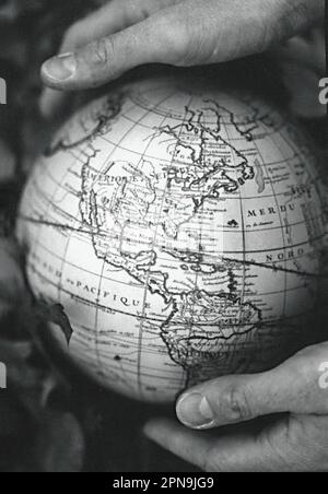 Two hands holding vintage globe of earth Stock Photo