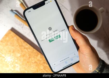 Gdansk, Poland - March 2023 Female hand holding cellphone Chat GPT app icon on screen of mobile phone iPhone Apple. Website of US American artificial intelligence company OpenAI LLC. Webpage prototype AI chatbot. Modern technologies  Stock Photo
