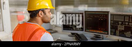 Young multiethnic operator working at concrete plant Stock Photo