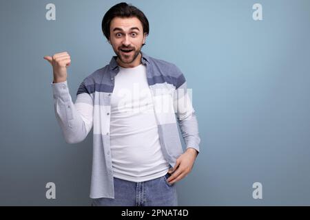 emotional young brutal brunette guy on a studio background for a poster Stock Photo