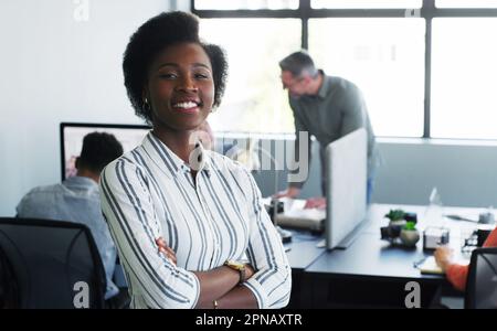 First rule of positive management Lead by example. Portrait of a confident young businesswoman working in a modern office with her colleagues in the Stock Photo