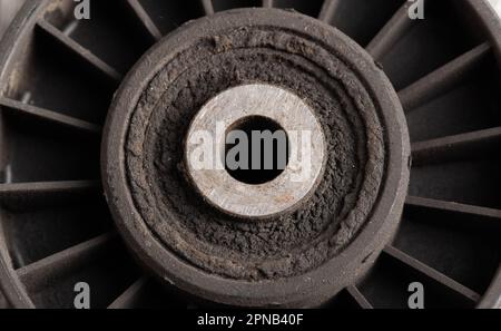 Old dirty car roller made of plastic and bearing on a gray background. Stock Photo