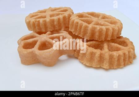 Close up of few deep fried Sri Lankan snacks known as the Kokis in a white plate Stock Photo