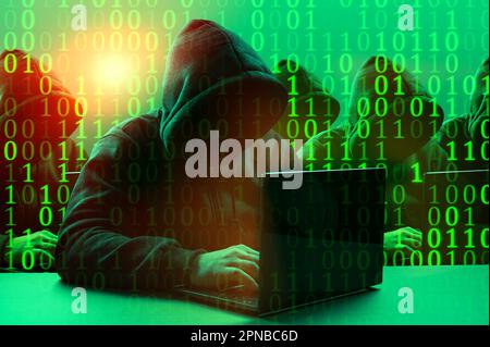 Group of hooded hackers in cybersecurity concept. Group of gloomy hackers in hoodies sitting in row and typing on keyboards fastly in server room. Mal Stock Photo
