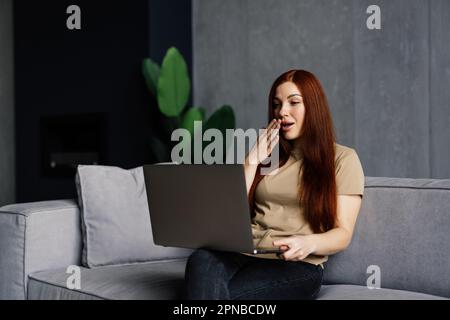 Shocked young woman with open mouth looking with amazement at laptop screen, reading unexpected news in message, surprised by message or email, watchi Stock Photo