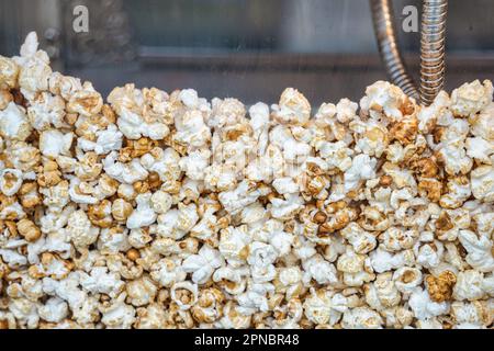 Close up with a fresh salty popcorn. Machine popcorn maker texture background. Stock Photo