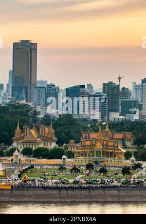 The golden sun hangs low over Cambodia's capital city,it's busy Riverside and famous landmark,the Royal Palace,as sunlight reflects from Tonle Sap riv Stock Photo