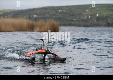 Aseleben, Germany. 18th Apr, 2023. The Sonobot swimming drone is in use. The device independently scans the bottom of the lake using sonar and can display images of it. This modern technology is being used for the first time in the search for underwater archaeological treasures on the bottom of Lake Suess. Credit: Heiko Rebsch/dpa/Alamy Live News Stock Photo