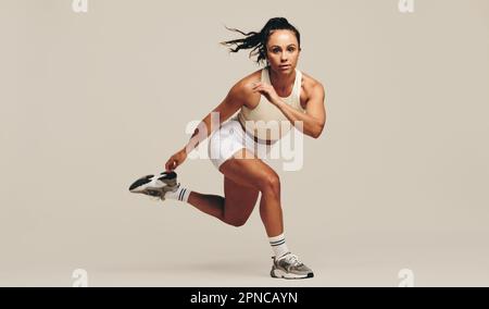 Young female athlete performing strength training exercises in a studio.  Sportswoman showing her dedication to improving her body fitness and  performa Stock Photo - Alamy