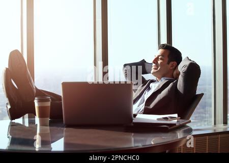 Feeling relaxed. a handsome young businessman looking relaxed while sitting in his office. Stock Photo