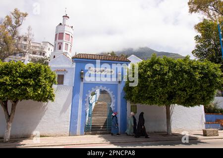 Chefchaouen, Morocco 2022: people walk in the unique narrow and coloured streets of the blue washed city of Chefchaouen,. popular touristic attraction Stock Photo