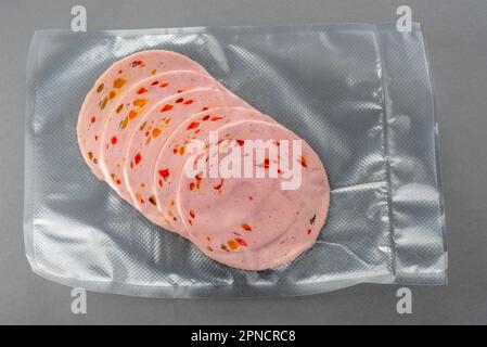 https://l450v.alamy.com/450v/2pncrc8/paprika-lyoner-sausage-slices-with-bell-pepper-in-vacuum-sealed-package-for-sous-vide-cooking-on-gray-background-2pncrc8.jpg