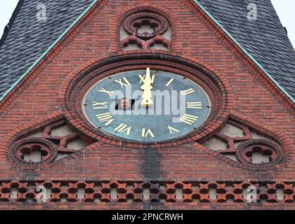 18 April 2023, Brandenburg, Frankfurt (Oder): Holger Bittner from the company Bittner Glocken- und Turmuhren looks out of an opening in the southern tower clock of the Friedenskirche at a height of 38 meters. On the same day, two employees of the Bittner company had remounted the restored and newly gilded hands and numerals of the church tower clock, which dates back to about 1900, on the dial. The clockwork had already been restored by the company. The restoration project around the tower clock arose in 2019 from civic engagement and is consequently coordinated by a working group consisting o Stock Photo