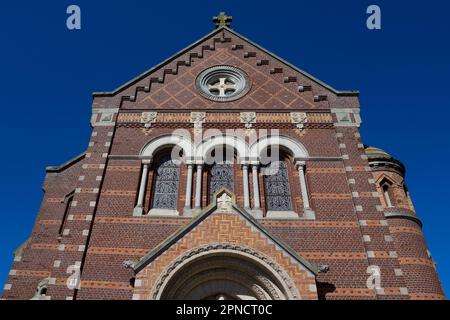 Exterior facade of the Romano-byzantine church of Saint Martin  in Mers-les-bains, in the Somme department of Northern France. Sunlit with blue sky. Stock Photo
