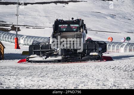 Huez, France - 9 April 2023: Snowcat, ratrack PistenBully - machine for snow preparation while working in Alpe D'huez Stock Photo
