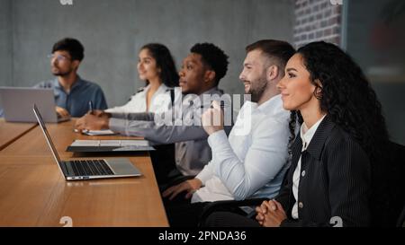 Diverse multiracial office workers multiethnic partners employees investors team watching presentation listening webinar business lecture presentation Stock Photo