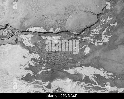 The structure of cracked wet earth at the bottom of the lake, creating irregular patterns, structure, background. Amazing shapes created by nature at Stock Photo