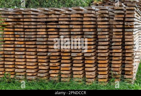 Piles of wooden boards in the sawmill, planking. Warehouse for sawing boards on a sawmill outdoors. Wood timber stack of wooden blanks construction ma Stock Photo