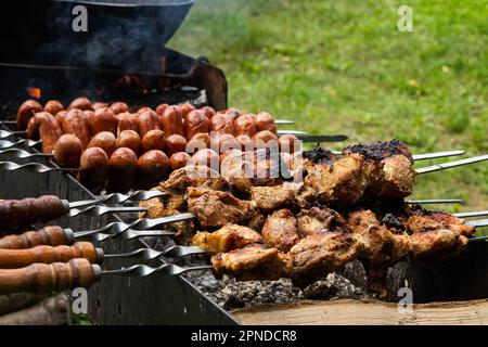 Marinated shashlik preparing on a barbecue grill over charcoal. Shashlik or Shish kebab popular in Eastern Europe. Shashlyk, skewered meat was origina Stock Photo