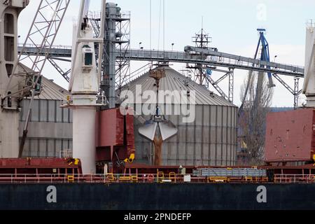 Loading sand onto a cargo barge in a seaport close-up Stock Photo