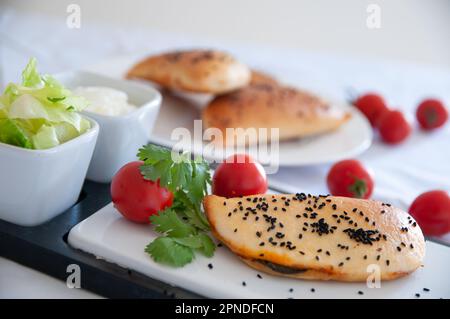 Pie served with salad and yoghurt Stock Photo