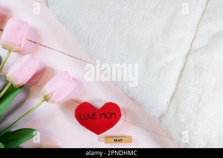 Everyday is mother's day. Mother's day concepts and Sweetest day, love concept. Red heart with the letter LOVE MOM with Beautiful flower on pink backg Stock Photo