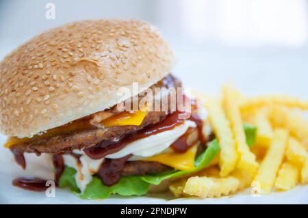 Double Cheeseburger served with fried potatoes Stock Photo