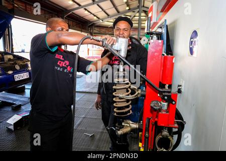 Two African American mechanics working on a car in a professional automotive repair shop Stock Photo