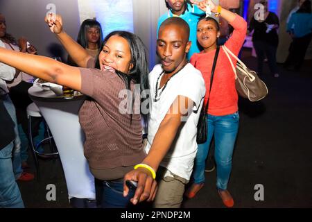 A young African American couple enjoying a night out at a nightclub, engaging in close dancing Stock Photo