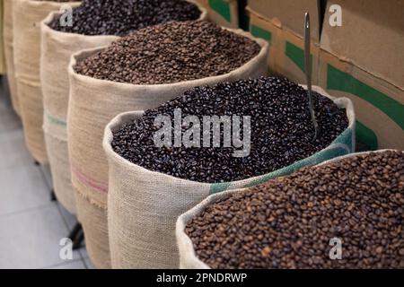 Freshly roasted coffee beans with a metal scoop, in jute sacks. Close-up with an open coffee bag. Arabic coffee beans in bag Stock Photo