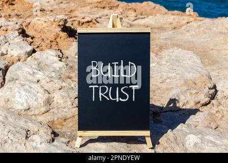 Build trust symbol. Concept words Build trust on black chalk blackboard on a beautiful stone background. Business and build trust concept, copy space. Stock Photo