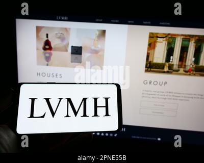 Person holding mobile phone with logo of company LVMH Moet Hennessy Louis  Vuitton SE on screen in front of web page. Focus on phone display Stock  Photo - Alamy