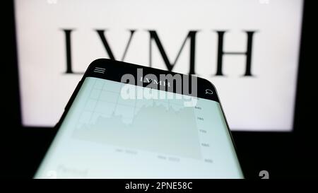 KONSKIE, POLAND - August 07, 2022: Smartphone displaying logo of LVMH Moet  Hennessy Louis Vuitton corporation on stock exchange chart background Stock  Photo