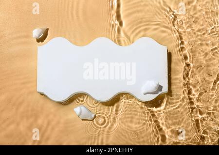 Plaster podium and seashells in water on beige background Stock Photo